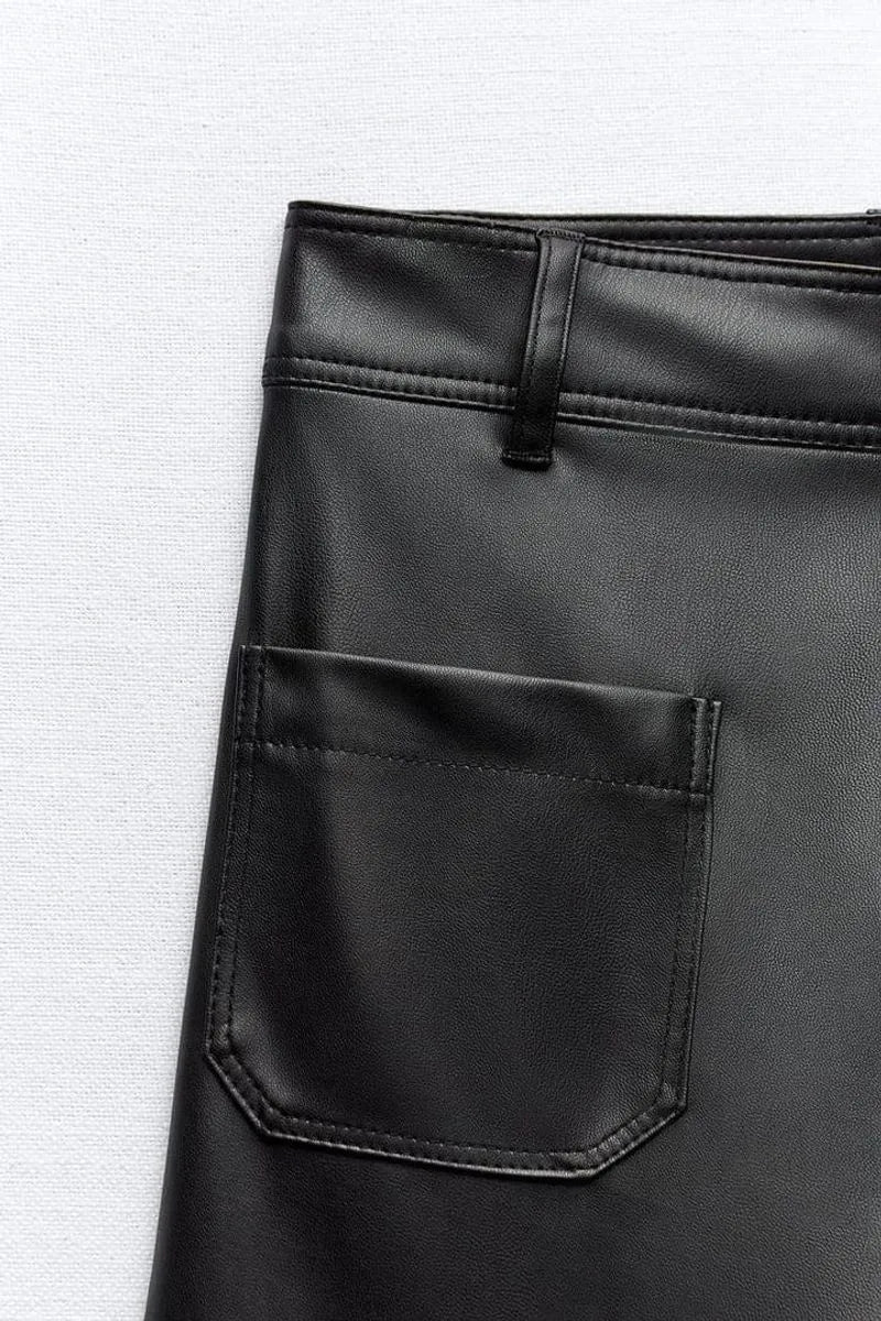 Close-up of a black leather pocket on a textured white background