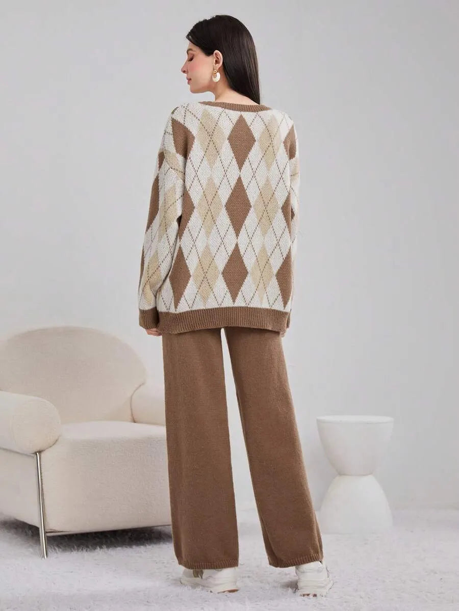 Person wearing a brown and beige argyle sweater with matching pants in a minimalistic room.