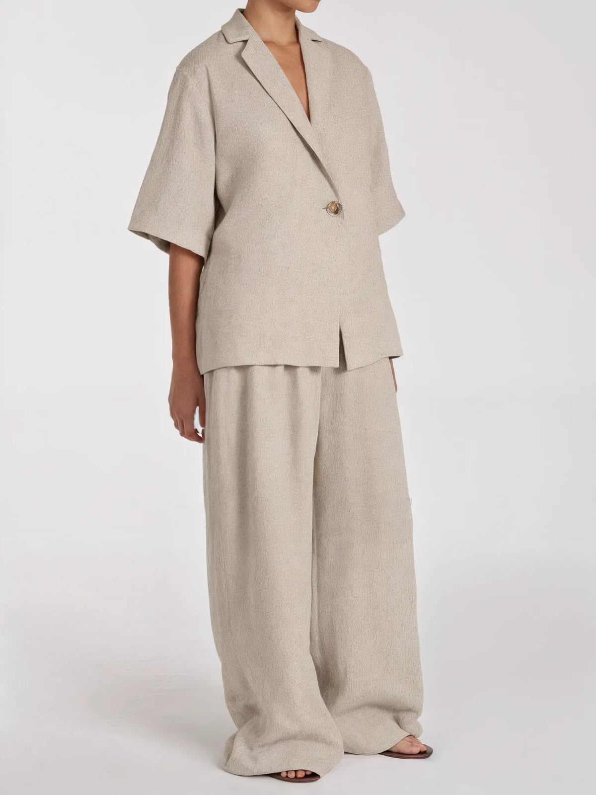 Person wearing a beige suit on a white background