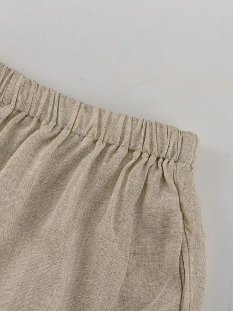 Close-up of beige pants with an elastic waistband on a light gray background