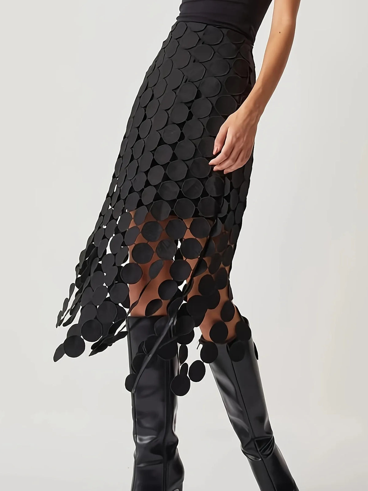 Black patterned skirt with sheer overlay worn by a person on a white background