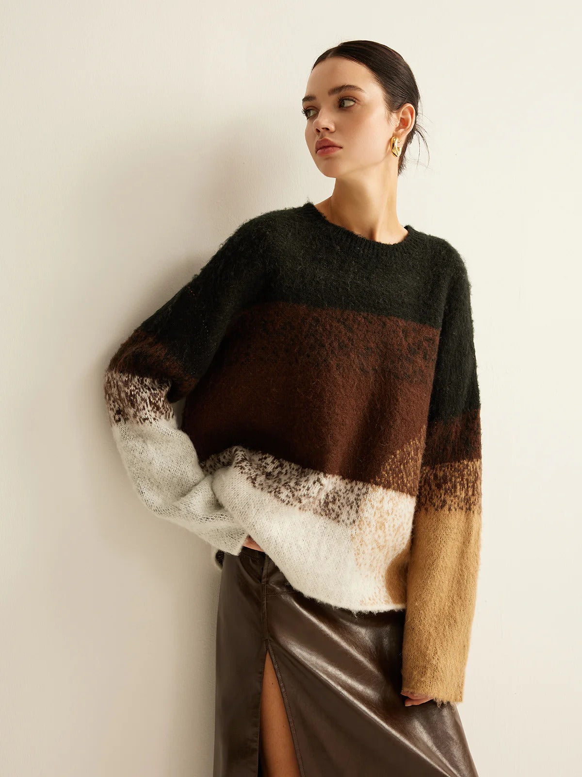 Woman wearing a multicolored sweater with a plain background