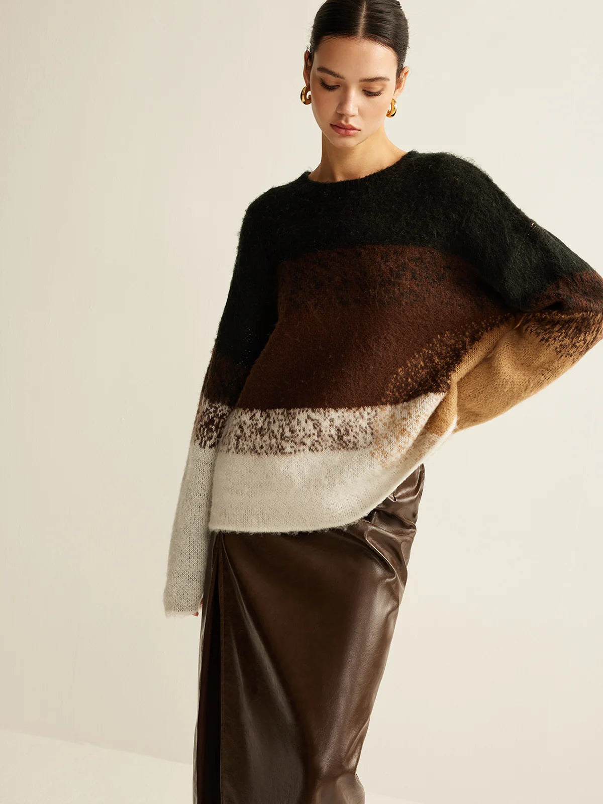 Woman wearing a color-blocked sweater with a neutral background