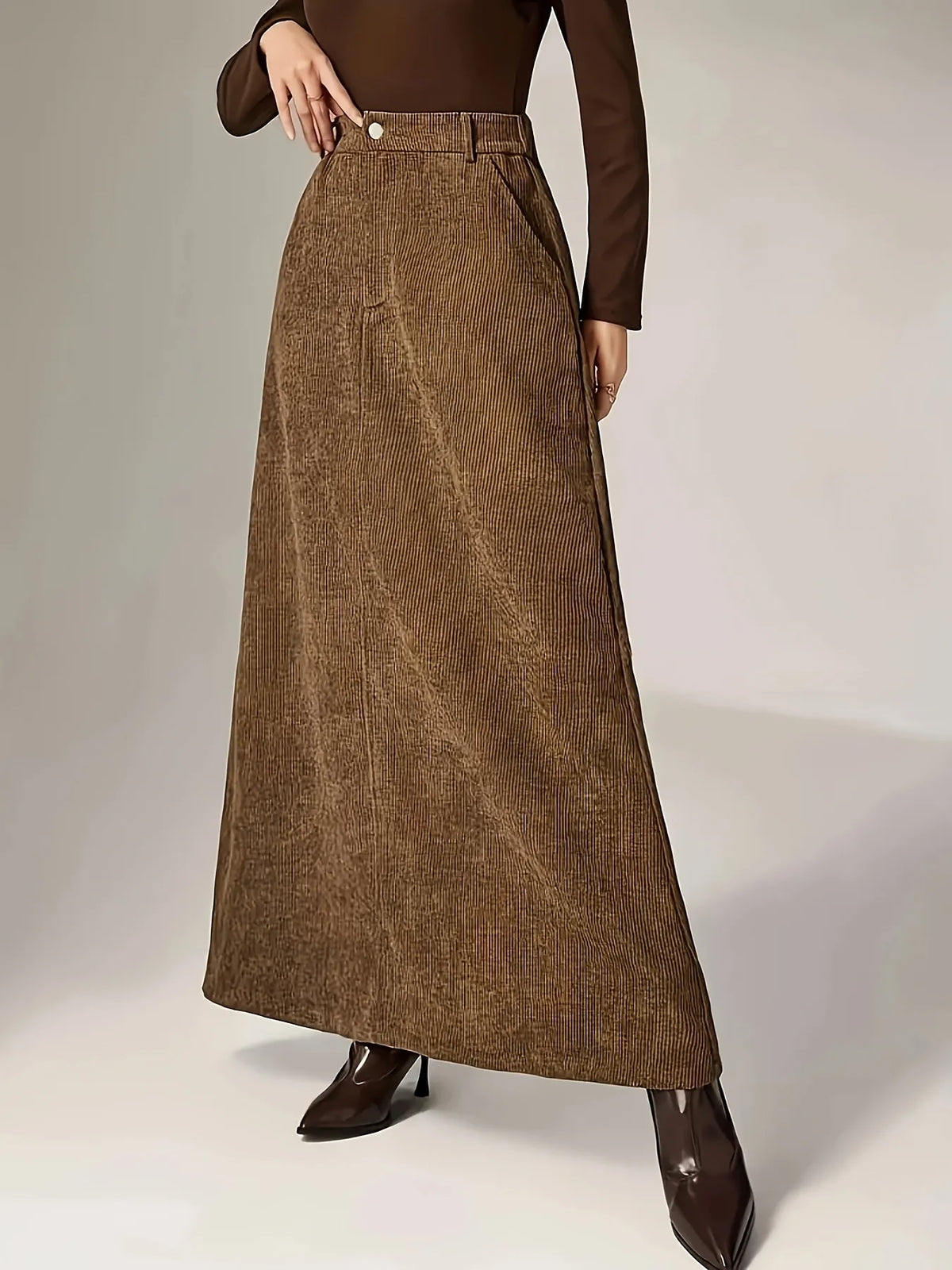 Brown corduroy skirt worn by a person on a plain background