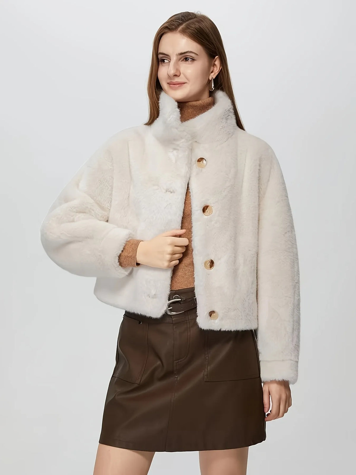 Woman wearing a cream-colored faux fur jacket on a white background