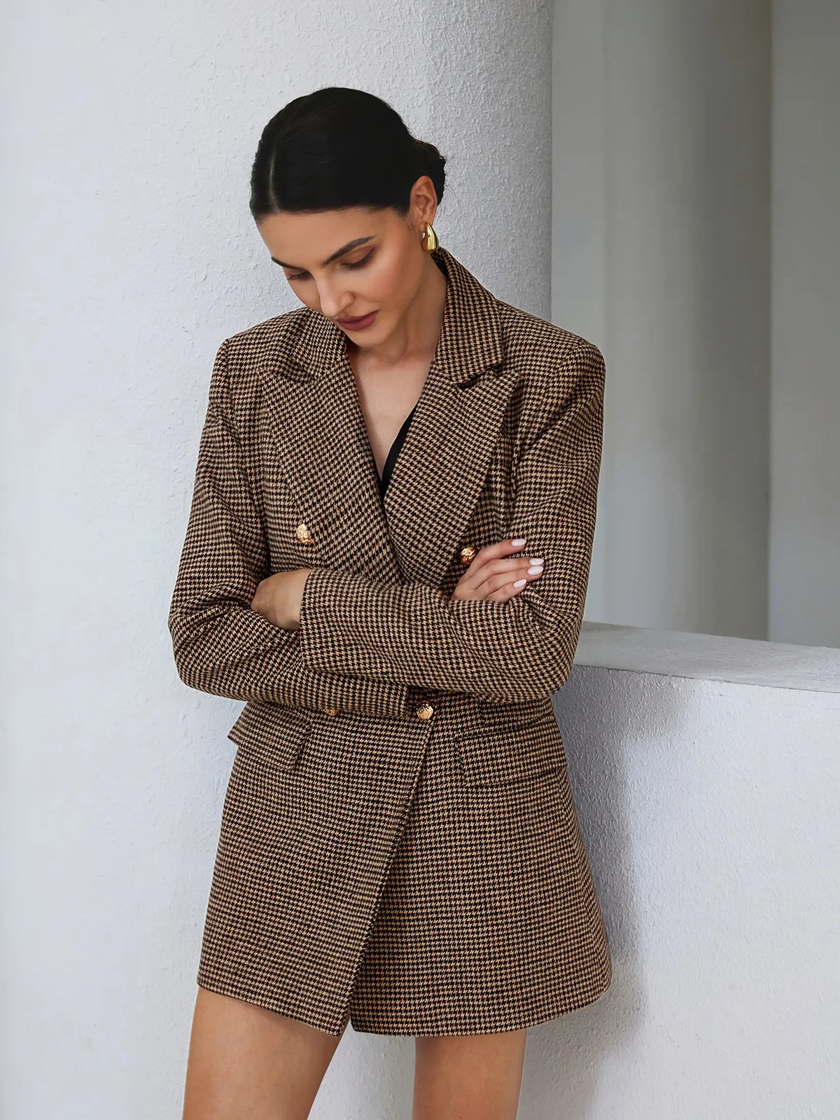 Woman wearing a brown checkered suit against a white background