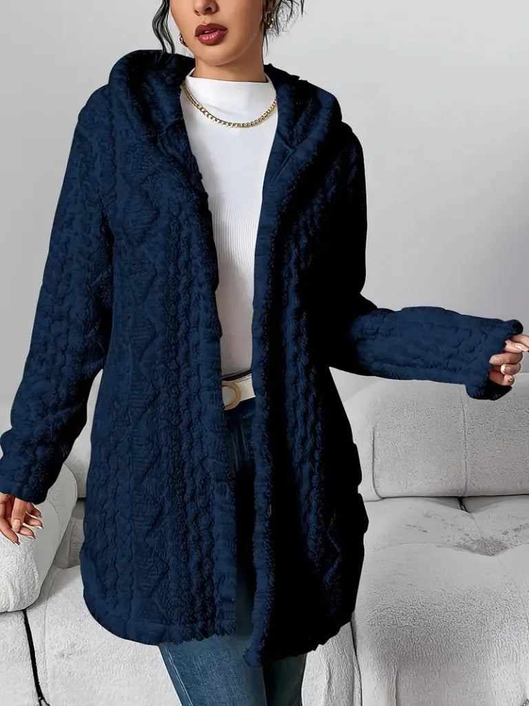 Person wearing a navy blue textured coat with a white background