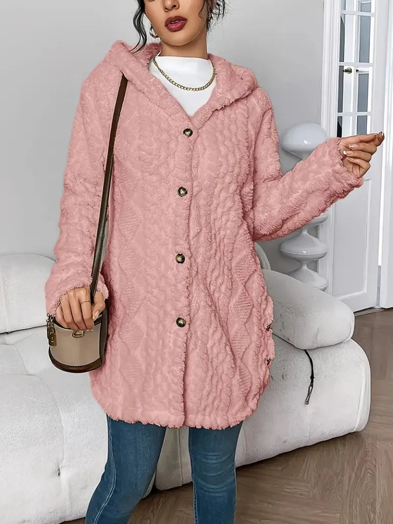 Person wearing a pink textured coat in a living room setting