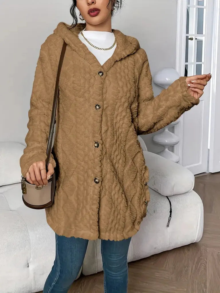 Person wearing a brown fur coat in a room with white furniture.
