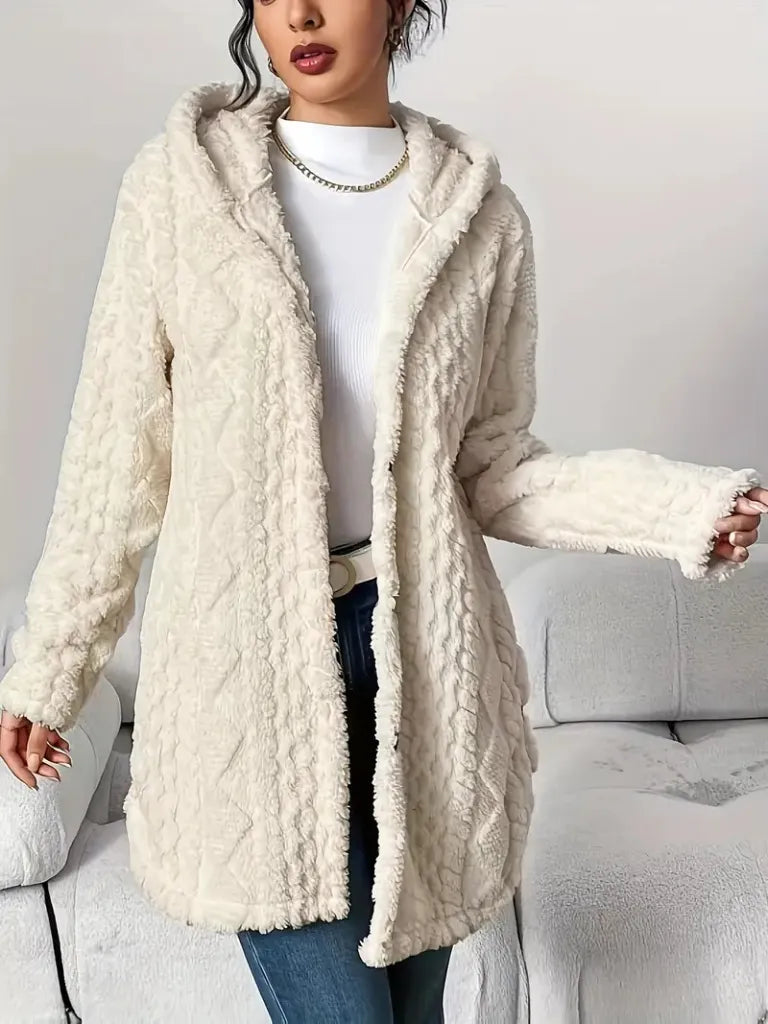 Person wearing a cream-colored fluffy coat in a neutral setting
