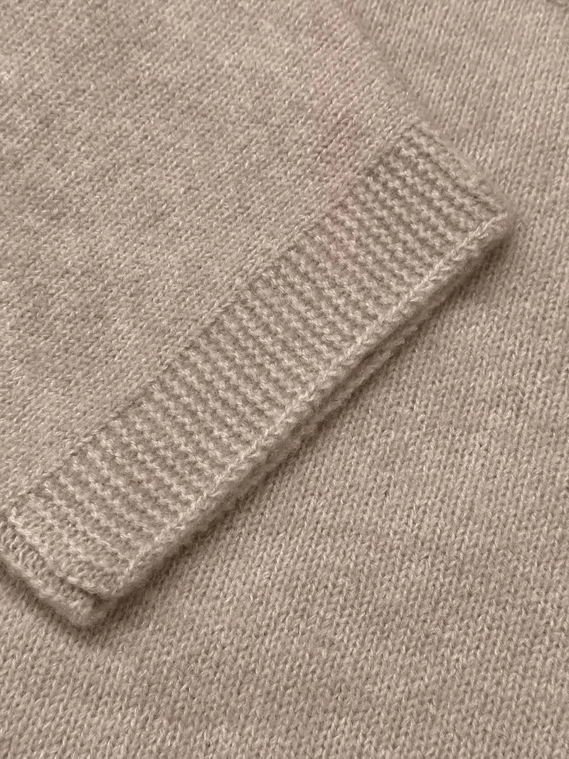 Close-up of a beige knitted fabric with ribbed texture.