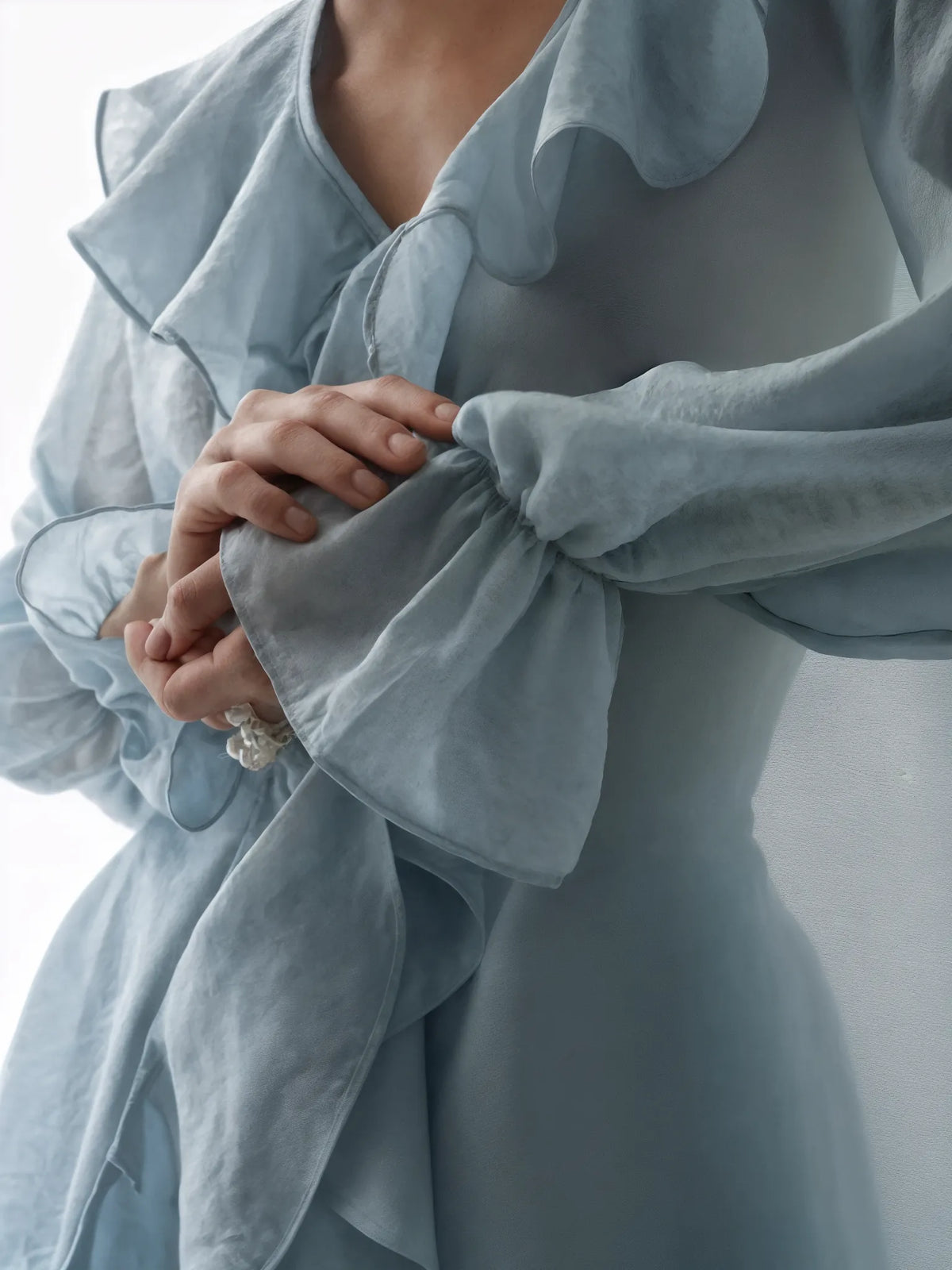 Light blue dress with ruffled details on a neutral background