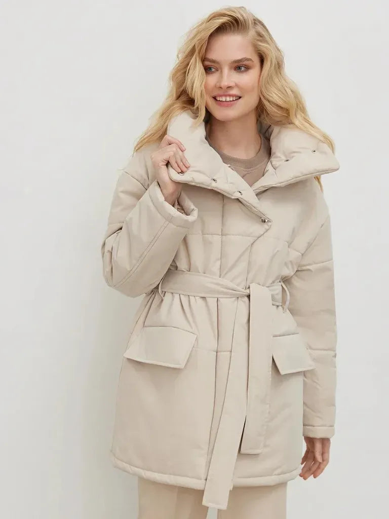 Woman wearing a beige coat against a white background