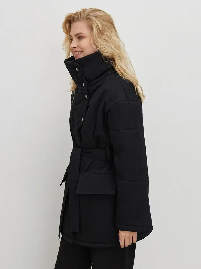 Woman wearing a black coat against a white background