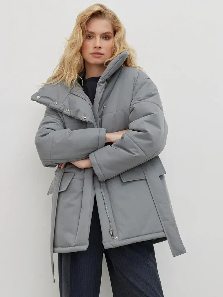 Woman wearing a gray coat against a white background
