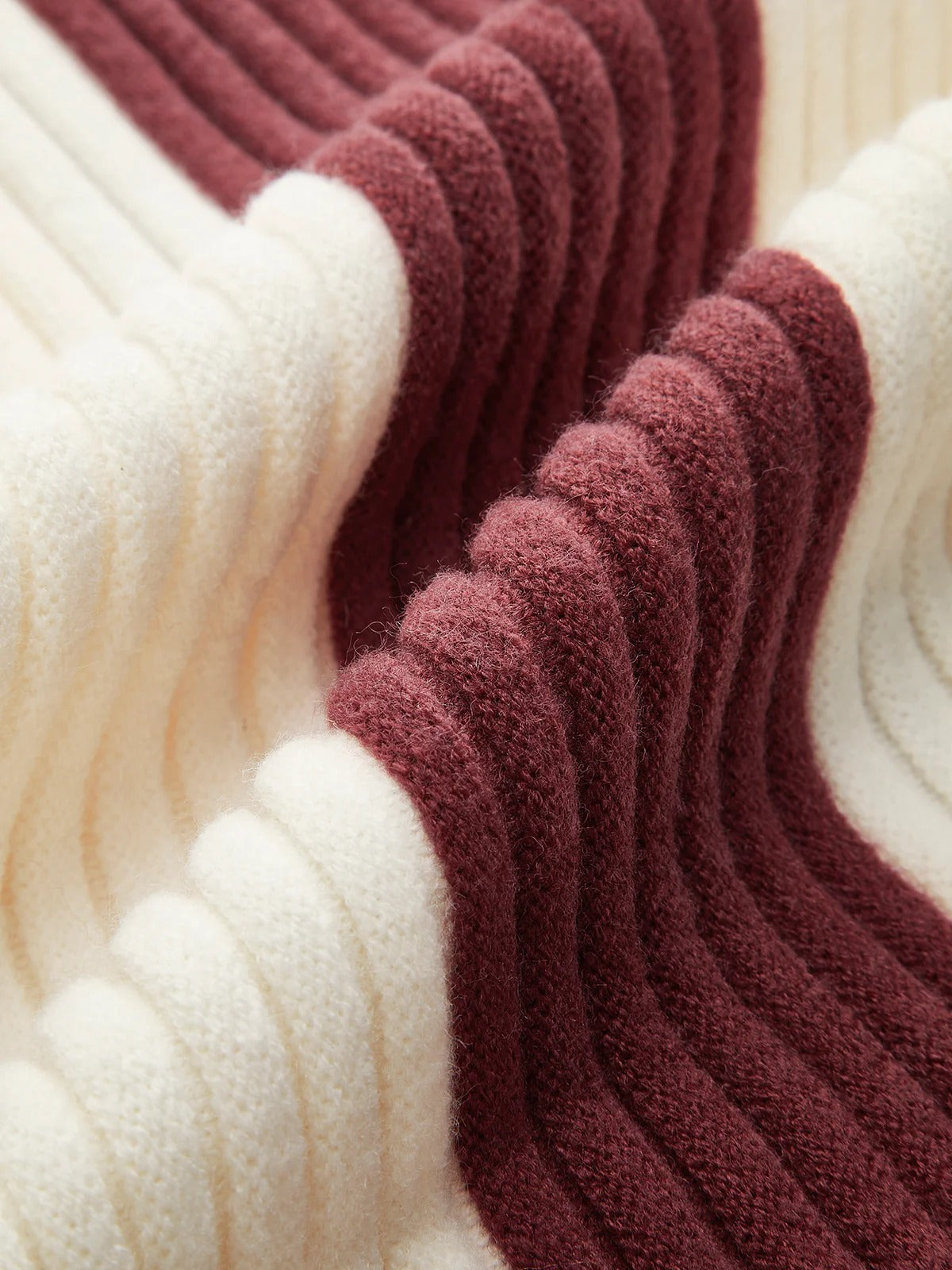 Close-up of ribbed yarn in white and burgundy colors.