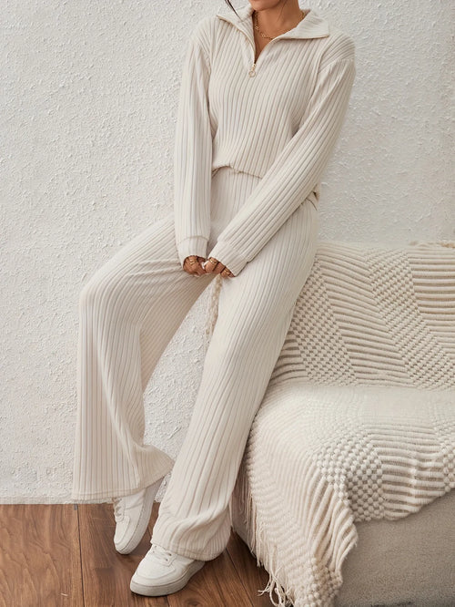 Person wearing a beige ribbed knit outfit sitting on a textured chair.