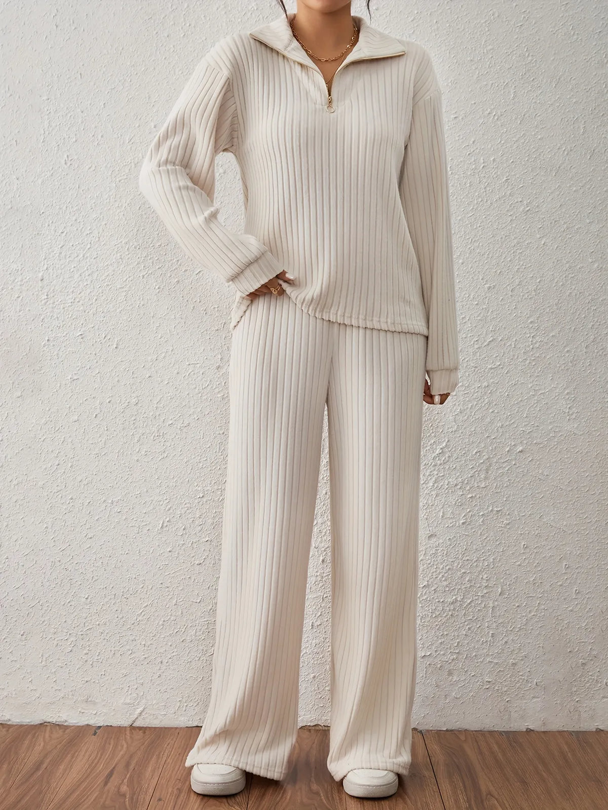 Person wearing a beige ribbed lounge set against a plain background