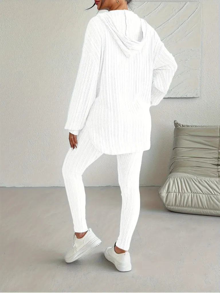 Person wearing a white outfit in a minimalistic room.