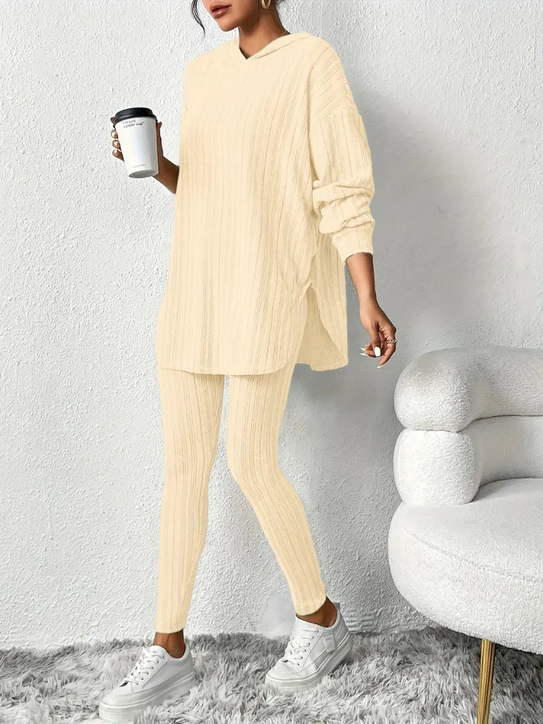 Person wearing a beige lounge set holding a coffee cup against a white background