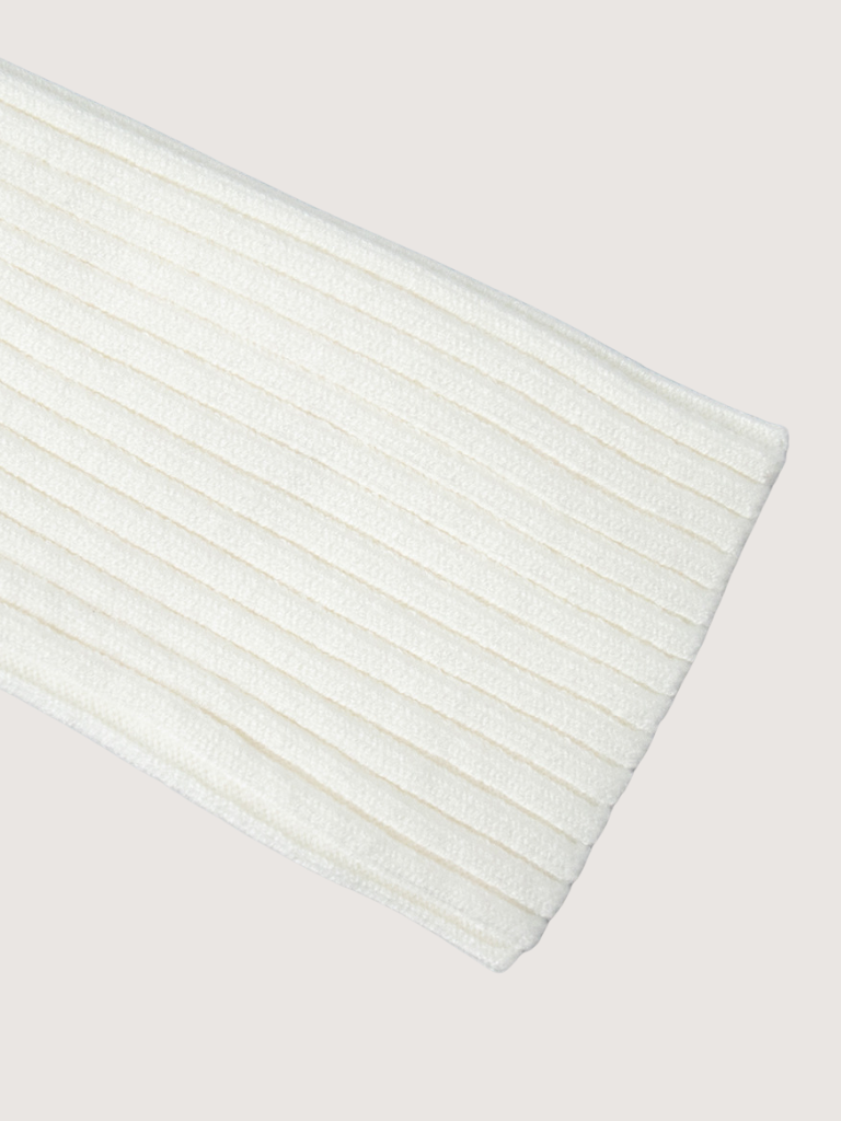 Close-up of a white ribbed knit fabric on a light gray background