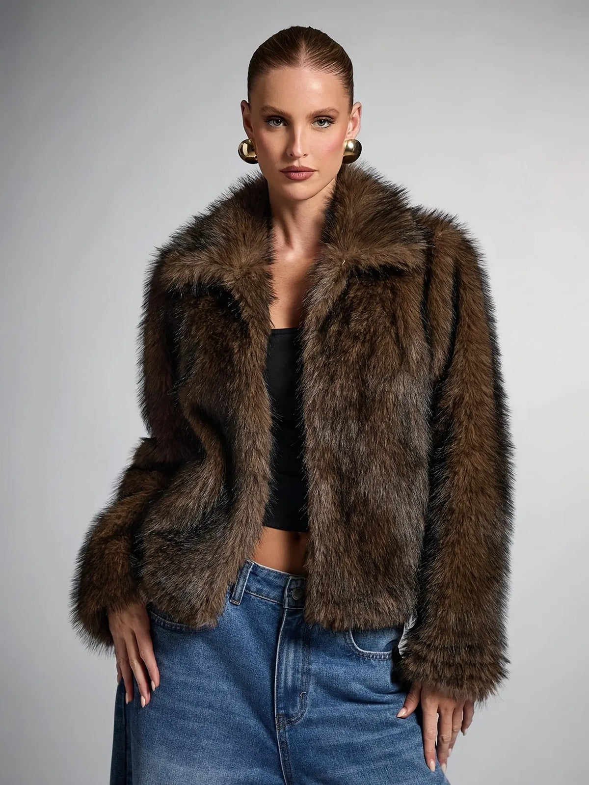Woman wearing a brown fur jacket against a gray background