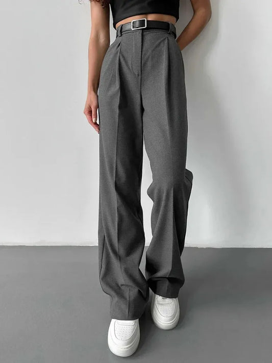 Person wearing gray wide-leg pants with a plain background