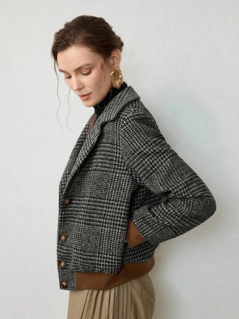 Woman wearing a checkered jacket with a plain background