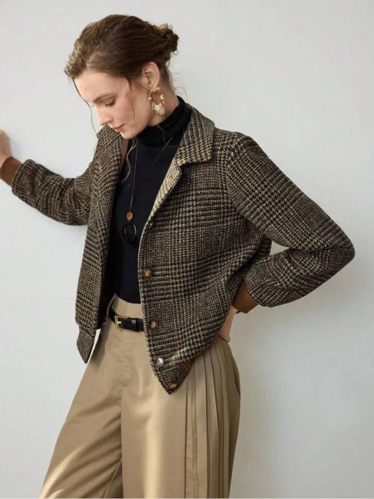 Woman wearing a plaid jacket with a plain background