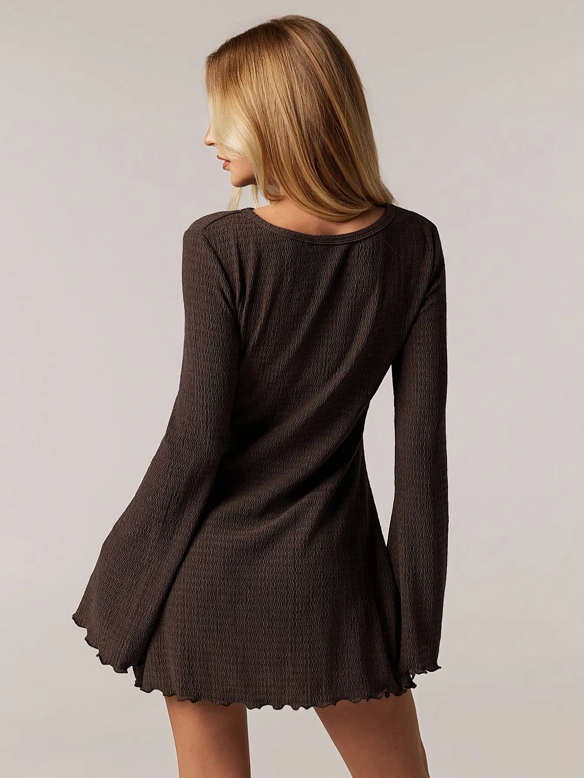 brown ribbed knit long-sleeve mini dress with flared sleeves and round neckline, fitted through the torso, casual yet elegant style