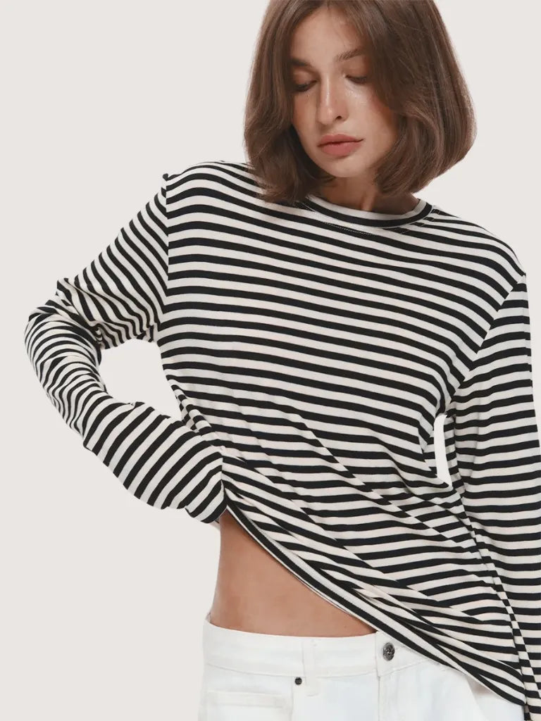 Person wearing a black and white striped long-sleeve top against a plain background