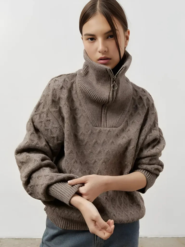 Person wearing a brown patterned sweater against a white background