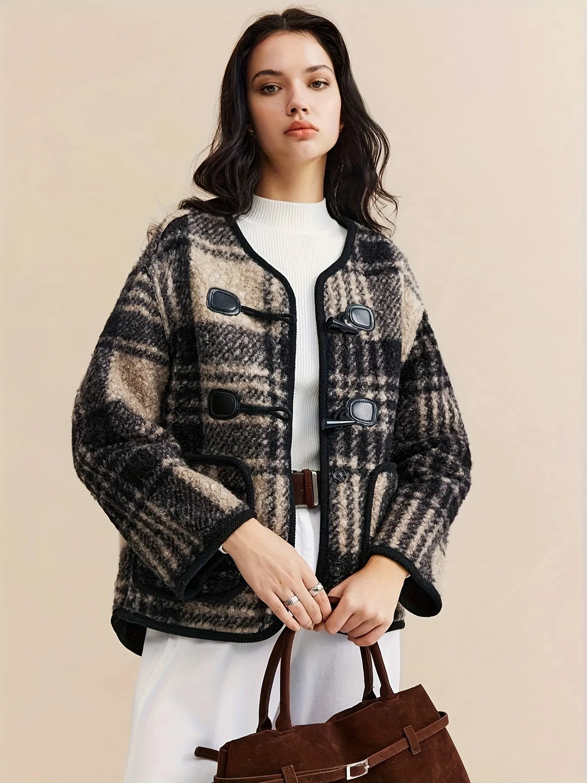 Woman wearing a plaid jacket with a plain background