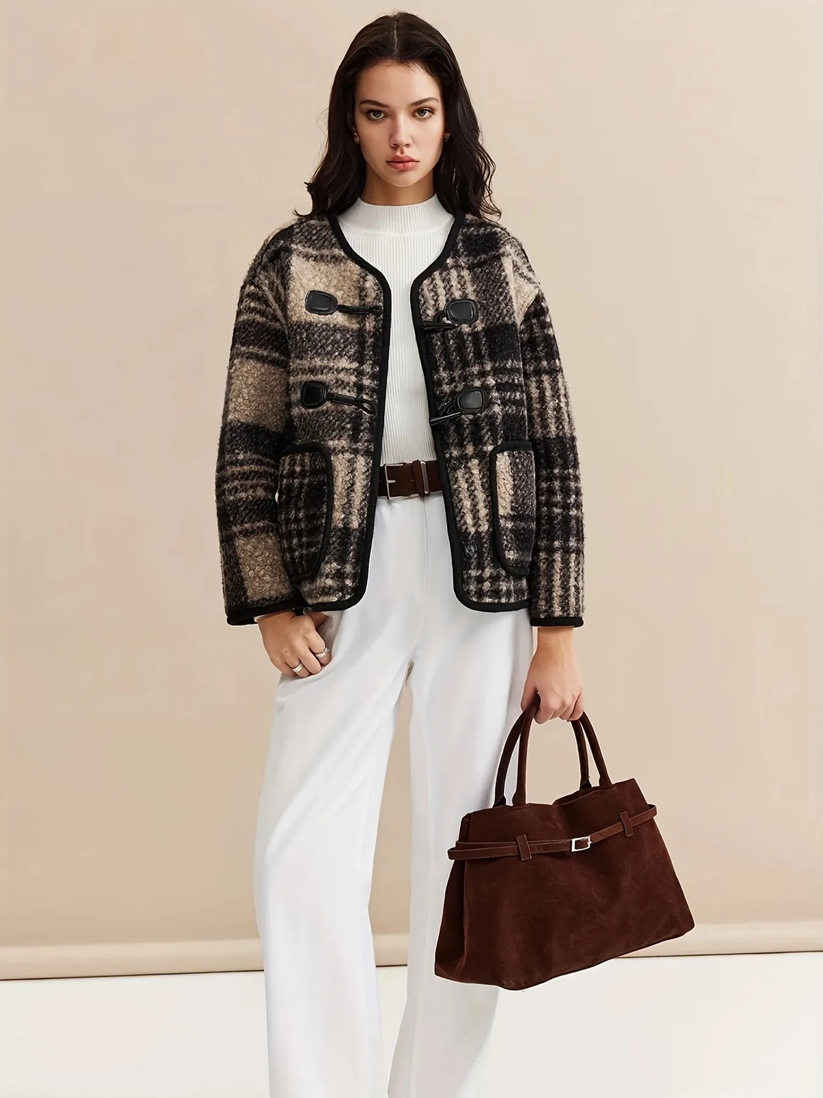 Woman wearing a plaid jacket with a plain background