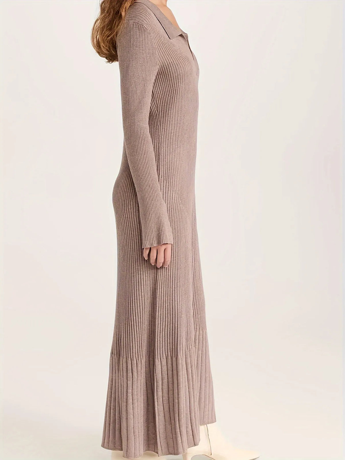 Woman wearing a long brown ribbed dress against a white background